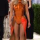 Kim Kardashian's tangerine-colored Met Gala look was a true piece of wearable pop art. She wore a custom fiberglass breastplate designed by iconic British artist Allen Jones in collaboration with the design team Whitaker Malem...